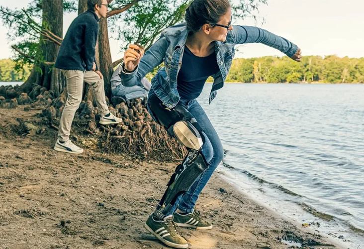 A woman throwing a stone in the water while wearing a C-Brace in New York and New Jersey