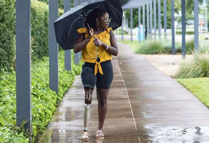 woman walking through the rain with her prosthetic in New Jersey & New York